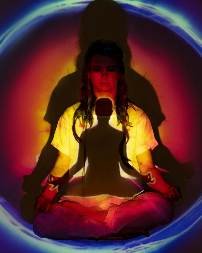 Woman practicing a calm yoga pose at sunrise, with amber light filtering through.